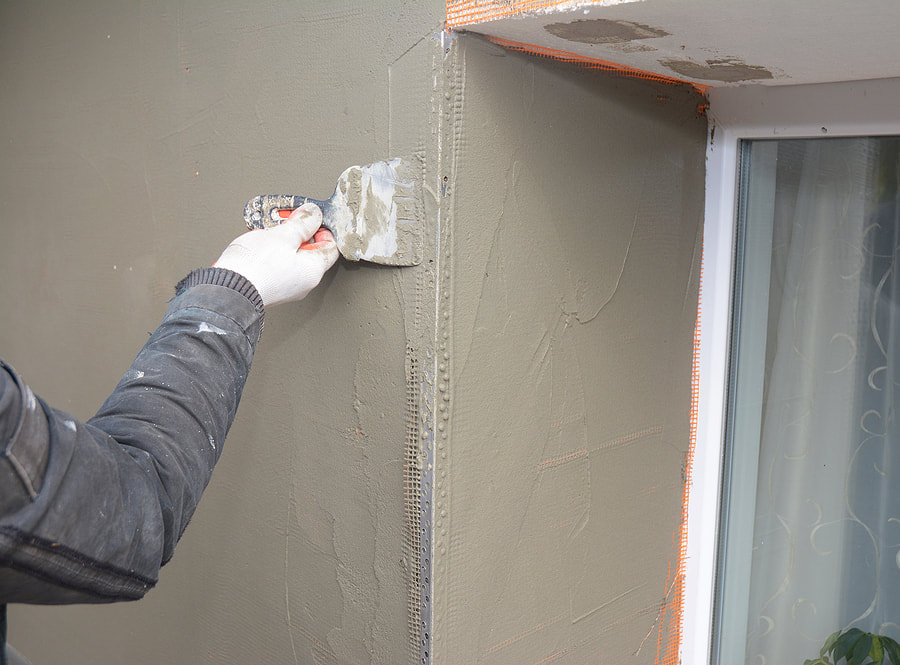 man applying cement to the wall